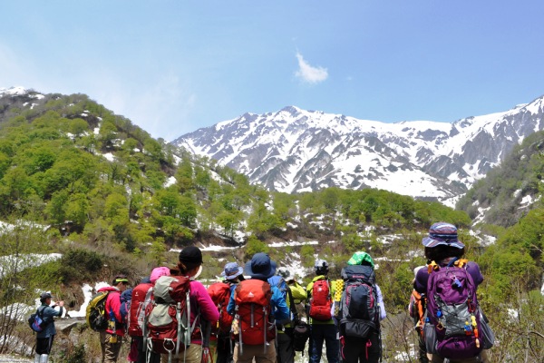 雪山見上げる登山者