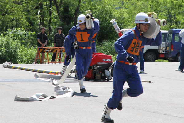 小型ポンプホース担ぐ選手