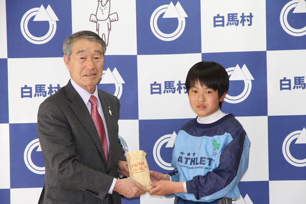 寄付金を受け取る村長
