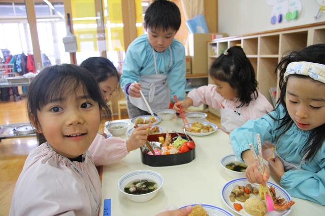おせちを食べる園児