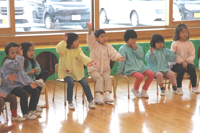 餅つきを眺める子ども達の写真