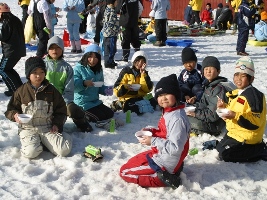 雪の上で軽食を食べる交流