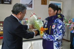 花束を渡す村長