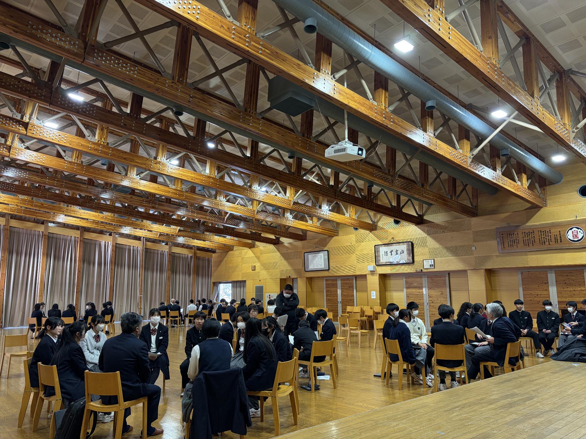 白馬中学生と議員がグループに分かれて話し合いをしている写真