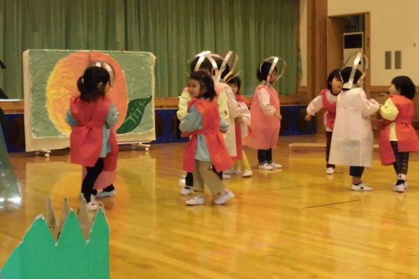 頭に飾りをつけた子供達が踊る様子の写真