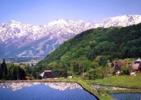 雪景色の北アルプスの山並みが、田園にくっきりと映し出された写真