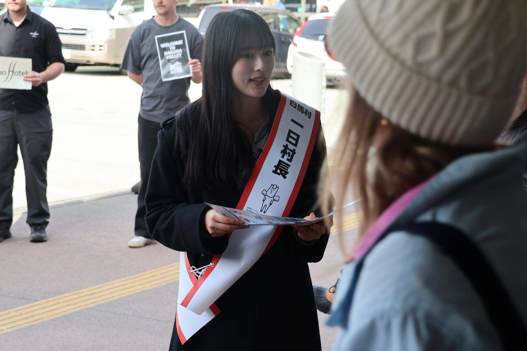 観光客に対して白馬村マナー条例のチラシを配る国本さん