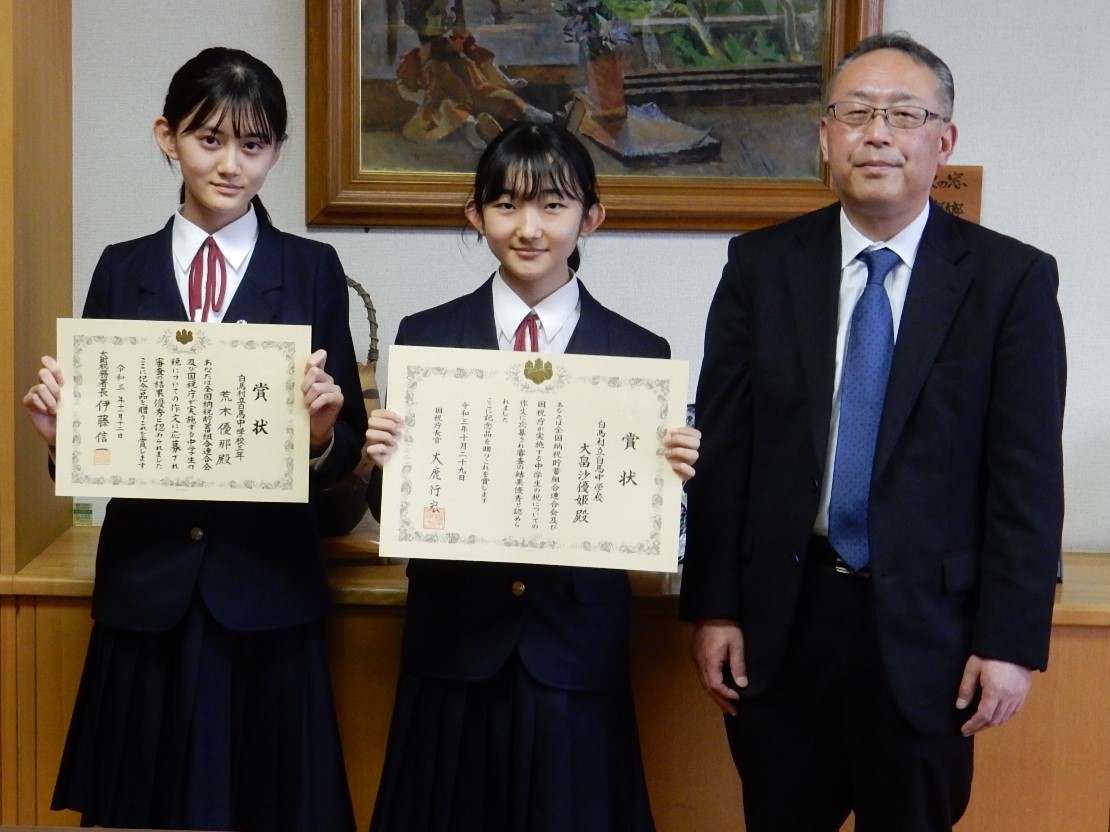 授与された表彰状を掲げて記念撮影