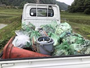 トラックの荷台に積まれた不法投棄されたごみの山の写真